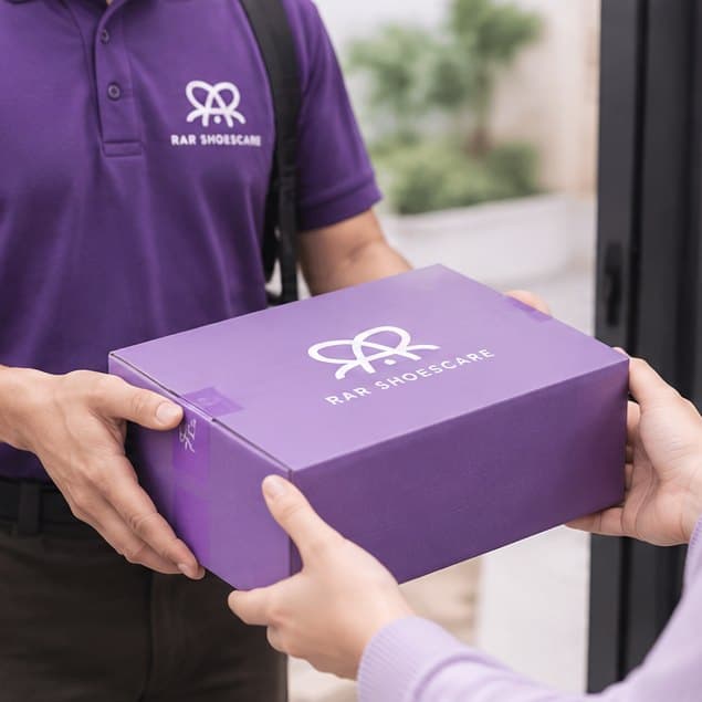 Kurir RAR Shoescare menyerahkan kardus berisi sepatu bersih kepada pelanggan