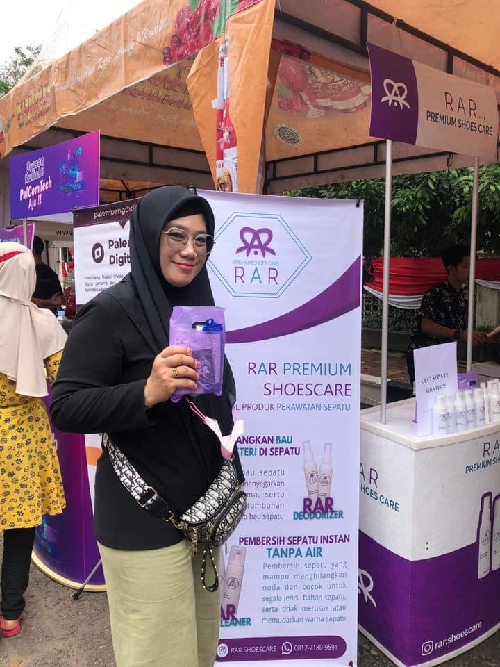 Pelanggan memegang paket produk RAR Shoescare di booth RAR