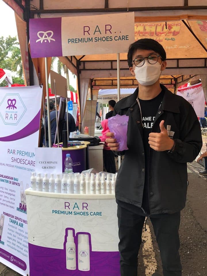 Pelanggan mengacungkan jempol di depan booth RAR Premium Shoes Care